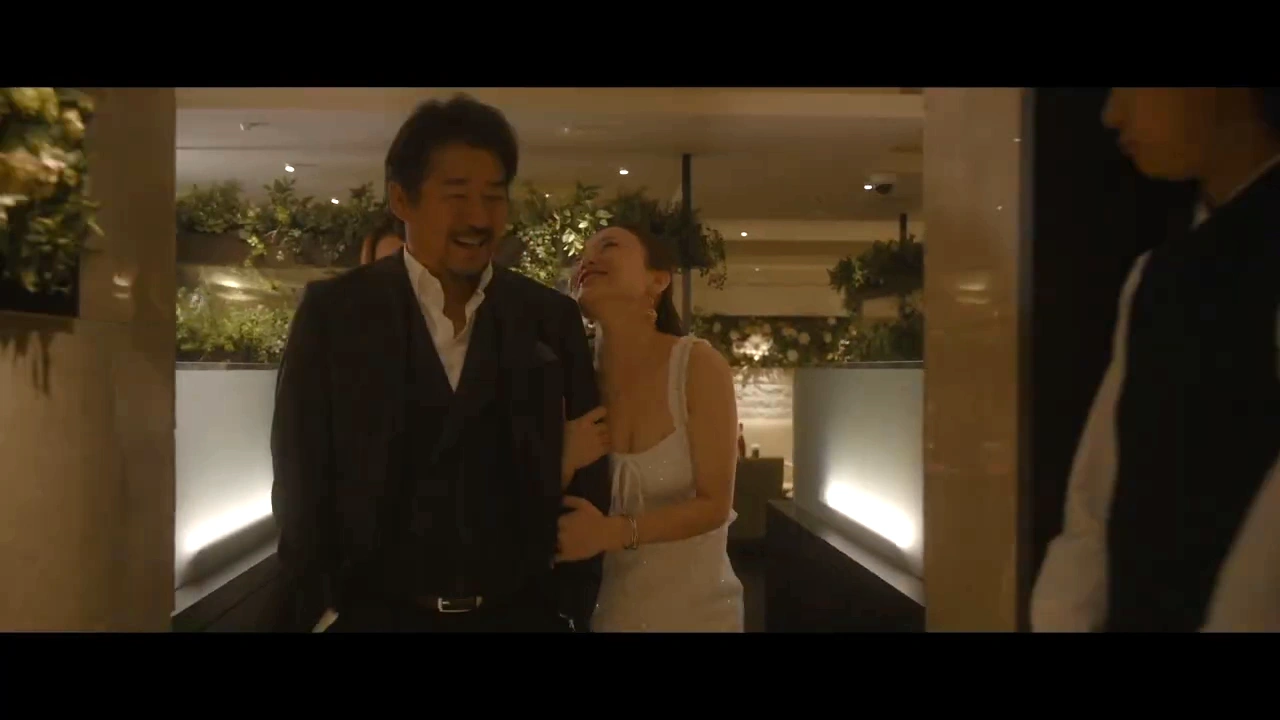 男性と腕を組んでクラブを歩く女性の場面