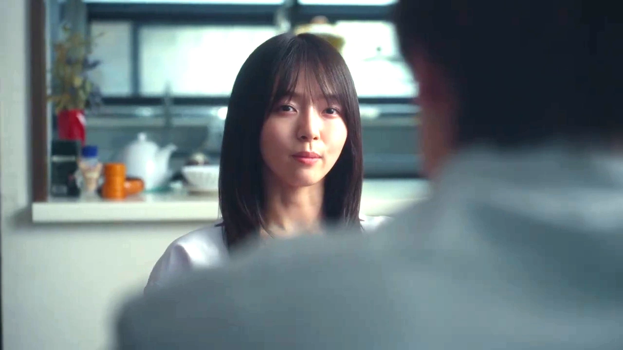映画『恋傷』で女性が室内で男性と向き合う場面