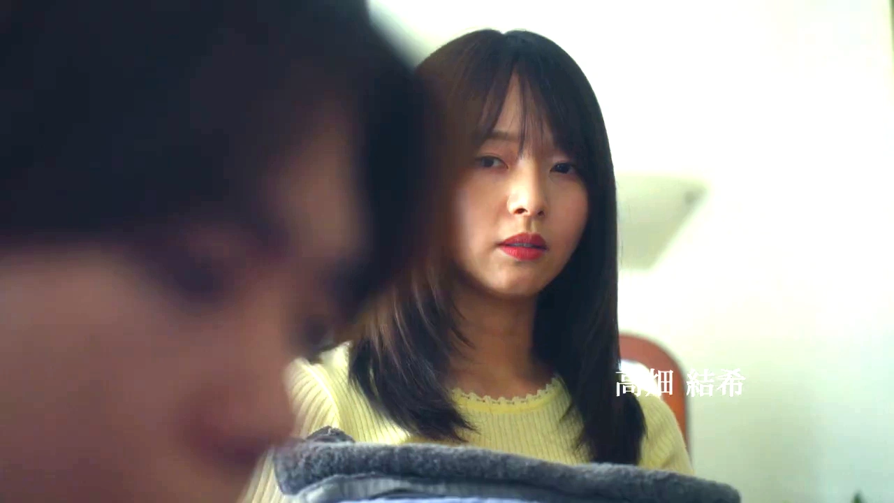 映画『恋傷』で女性が男性のそばに立つ場面