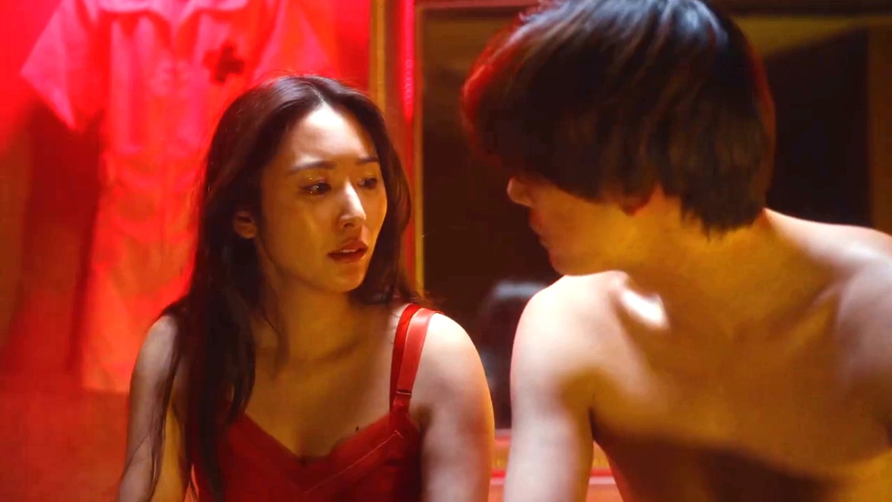 映画『恋傷』予告編で赤い照明の室内に男女が座る場面