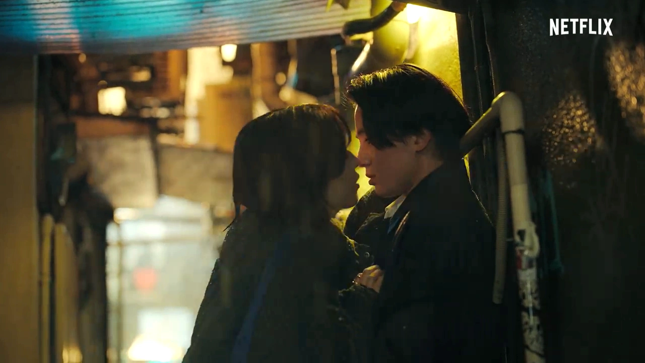 夜の壁際で近い距離から向き合う二人