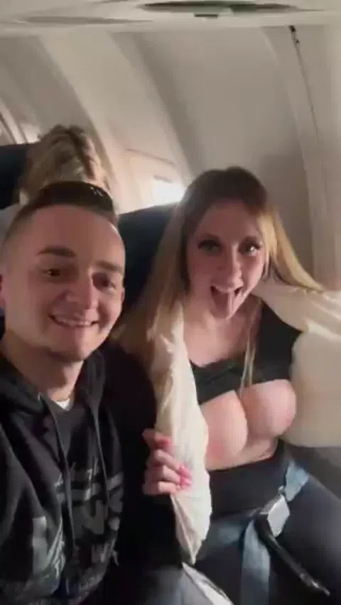 飛行機内でセクシーな胸を披露する女性