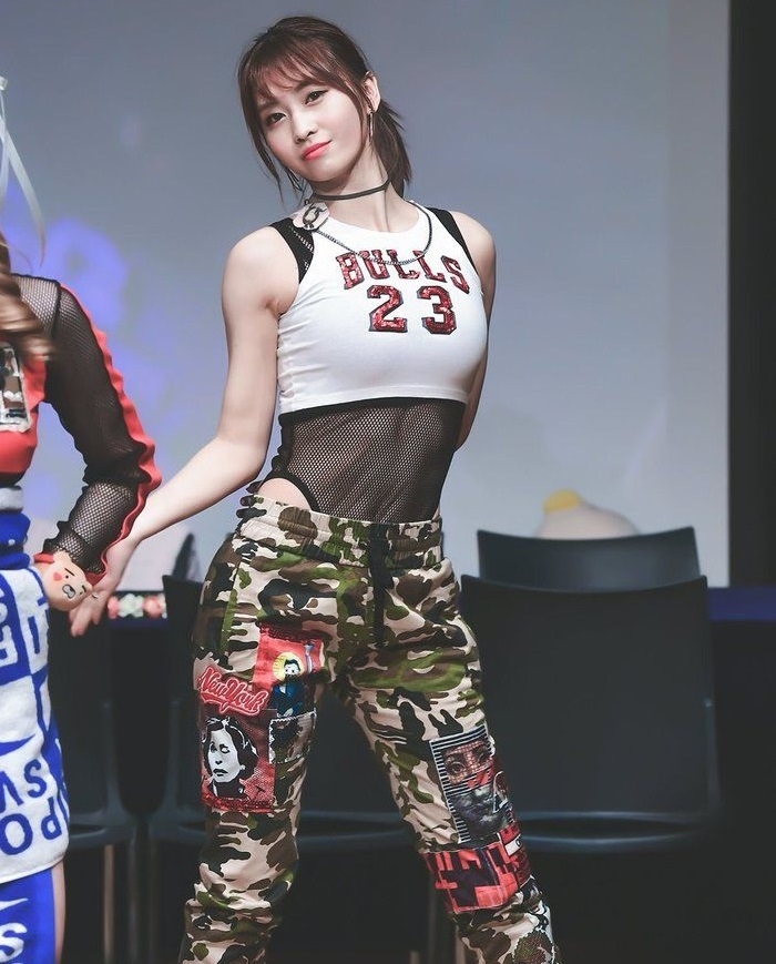 TWICE members in bold, shimmering costumes, delivering a powerful performance at their 2025 Japan tour.